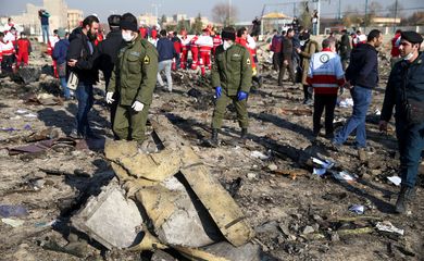 
Oficiais de segurança e trabalhadores do Crescente Vermelho são vistos no local onde o avião da Ukraine International Airlines caiu após a decolagem do aeroporto Imam Khomeini, no Irã, nos arredores de Teerã, no Irã, em 8 de janeiro de 2020.