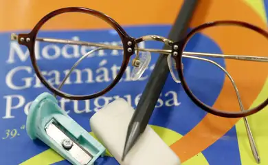 Brasília (DF), 07/02/2025 - Saúde ocular de alunos pede atenção na volta às aulas. Óculos em cima de gramática com lápis, borracha e apontador. Foto: Bruno Peres/Agência Brasil