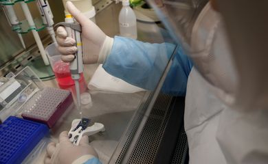Um cientista da Agência de Ciência e Tecnologia da Equipe Doméstica (HTX) demonstra, sem uma amostra viva, o processo de carregamento de ácido ribonucleico (RNA) extraído de uma amostra em um chip de teste molecular do kit de teste de