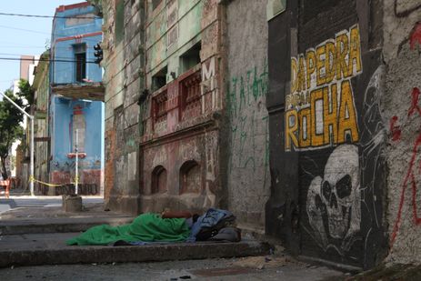 São Paulo (SP), 05/05/2023 - Mulher negra em situação de vulnerabilidade social dorme em fente aos casarões lacrados na rua Helvétia, de onde o fluxo da Cracolândia foi dispesado após a Operação Caronte. Foto: Rovena Rosa/Agência Brasil