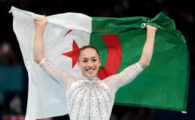 Ginasta argelina Kaylia Nemour posa para foto com a bandeira de seu país após conquistar a medalha de ouro nas barras assimétricas na Olimpíada Paris 2024
04/08/2024 Reuters/Mike Blake/Proibida reprodução