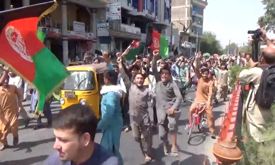 Pessoas carregando bandeiras do Afeganistão protestam contra o Taliban em Jalalabad