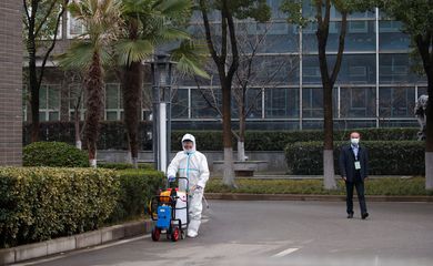 01/01/2021 Funcionário com traje de proteção desinfecta pavimento antes de chegada de equipe da OMS a centro de prevenção de doenças animais em Wuhan