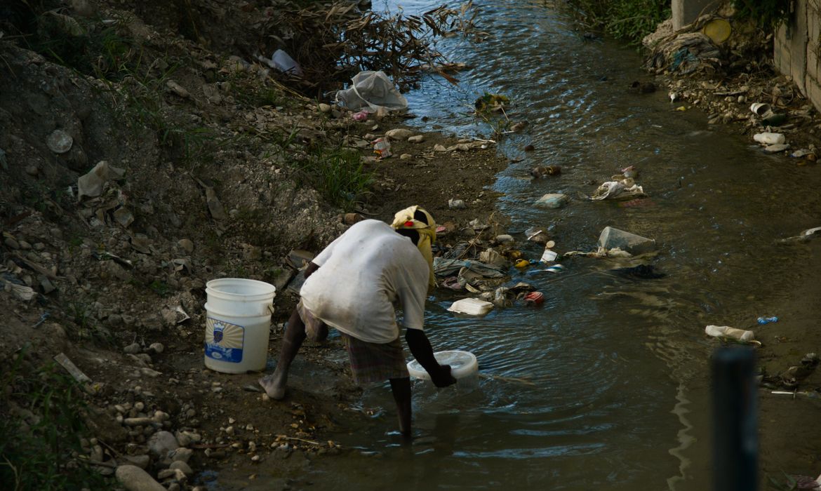 Porto Principe (Haiti) - Mulher pega água do esgoto em Boulevard 15 Octobre