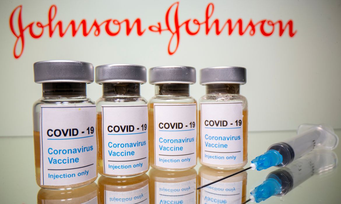 REUTERS/Dado Ruvic/Direitos Reservados Frascos rotulados como de vacina contra Covid-19 em frente ao logo da Johnson & Johnson em foto de ilustração