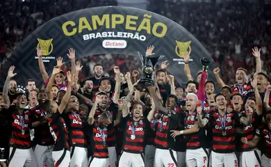 Soccer Football - Brasileiro Championship - Flamengo v Ceara - Estadio Maracana, Rio de Janeiro, Brazil - December 3, 2025 Flamengo's Giorgian de Arrascaeta and Bruno Henrique lift the trophy as they celebrate with teammates after winning the Brasileiro Championship REUTERS/Ricardo Moraes