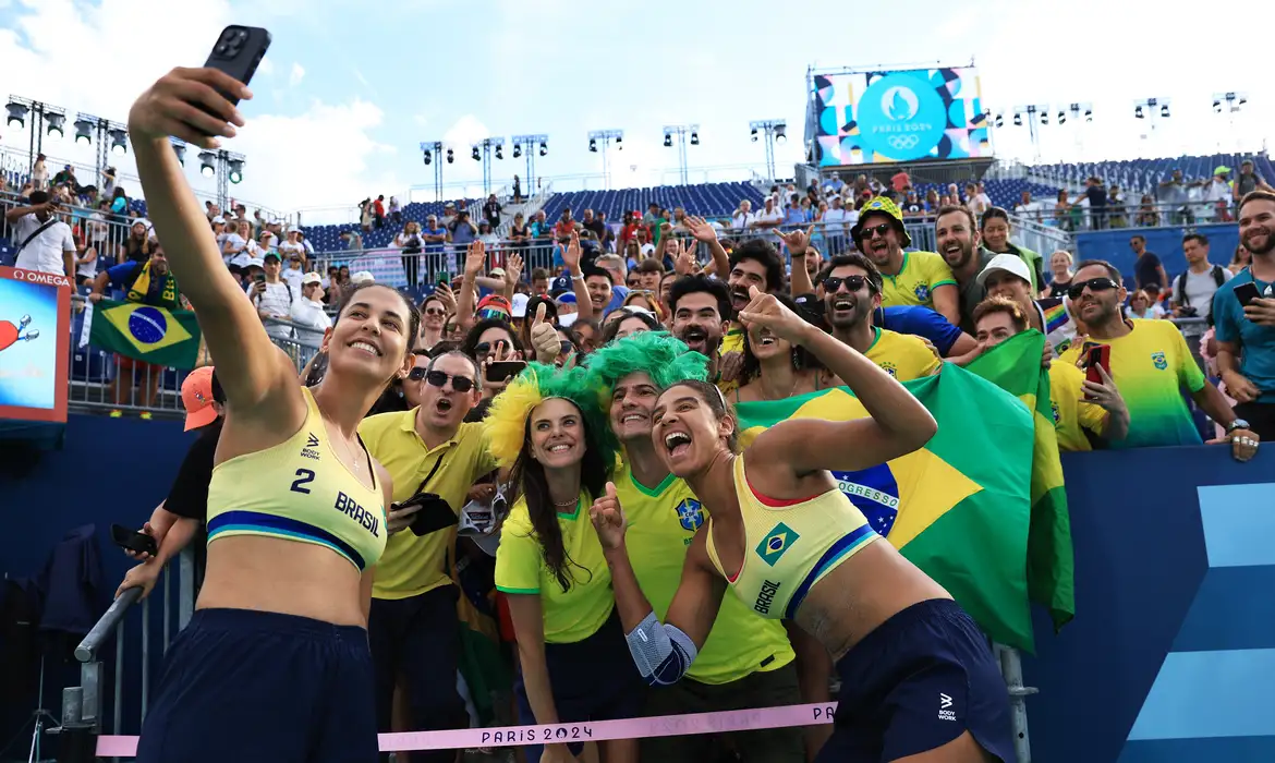 Paris 2024 Olympics - Beach Volleyball - Women's Quarterfinal - Brazil vs Latvia (Ana Patricia/Duda vs Tina/Anastasija) - Eiffel Tower Stadium, Paris, France - August 07, 2024. Ana Patricia Silva Ramos of Brazil and Eduarda Santos Lisboa of Brazil take pictures with fans after winning a match Reuters/Esa Alexander/Proibida reprodução