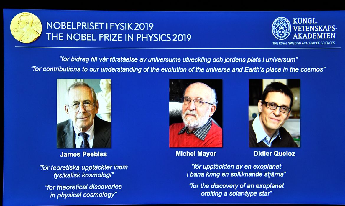 A screen displays the portraits of the laureates of the 2019 Nobel Prize in Physics (L-R) James Peebles, Michel Mayor and Didier Queloz, during a news conference at the Royal Swedish Academy of Sciences in Stockholm, Sweden, October 8, 2019.