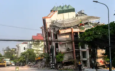 A rescue worker stands in front of a damaged building following a strong earthquake in Mandalay, Myanmar, April 3, 2025. REUTERS/Stringer