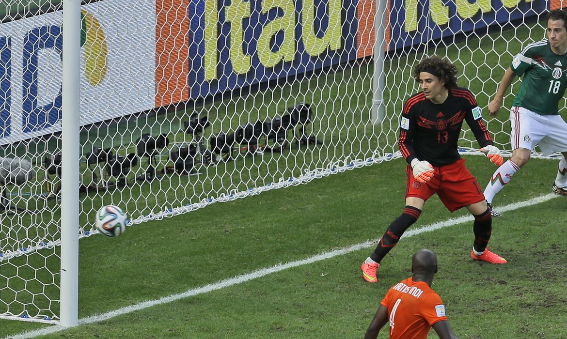 Mexico's goalkeeper Guillermo Ochoa looks to the ball as Netherlands' Wesley Sneijder scores his side's first goal during the World Cup round of 16 soccer match between the Netherlands and Mexico at the Arena Castelao i