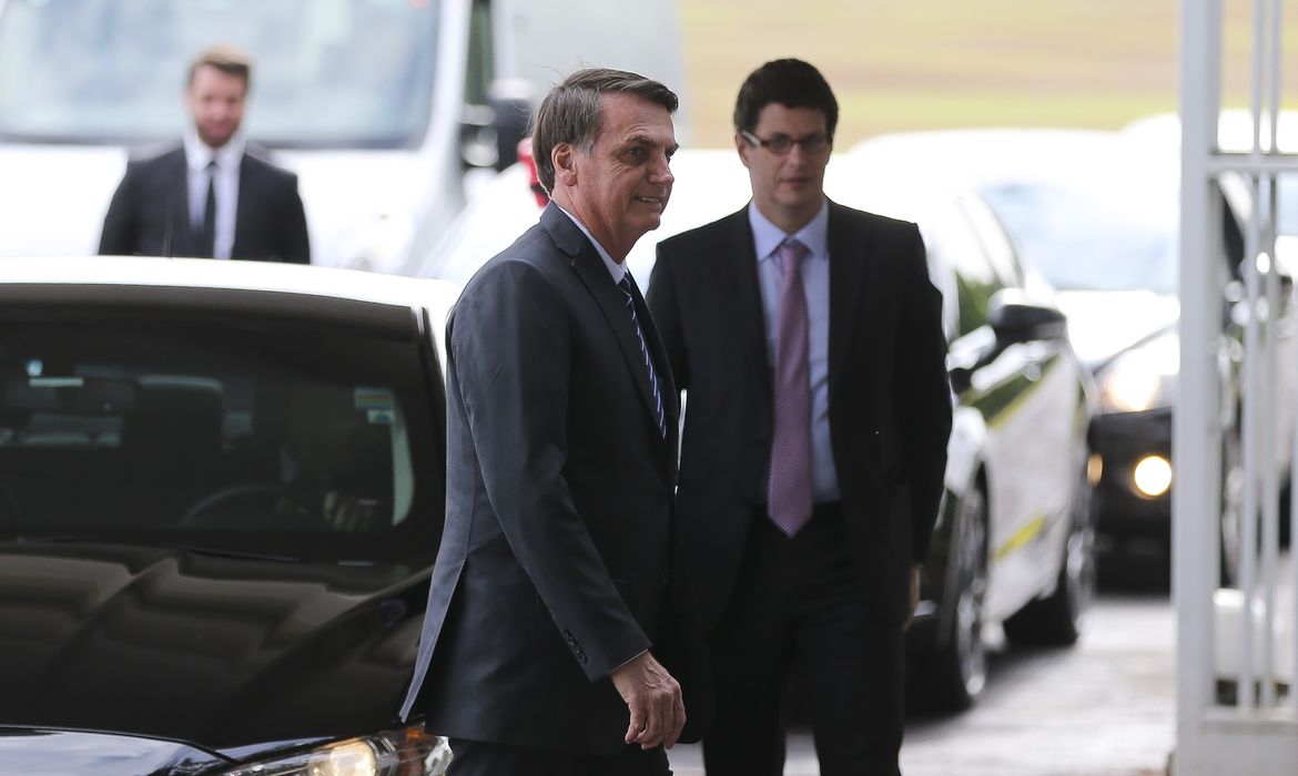 O presidente Jair Bolsonaro e o ministro do Meio Ambiente, Ricardo Salles recebem cumprimentos de turistas na entrada do Palácio da Alvorada.