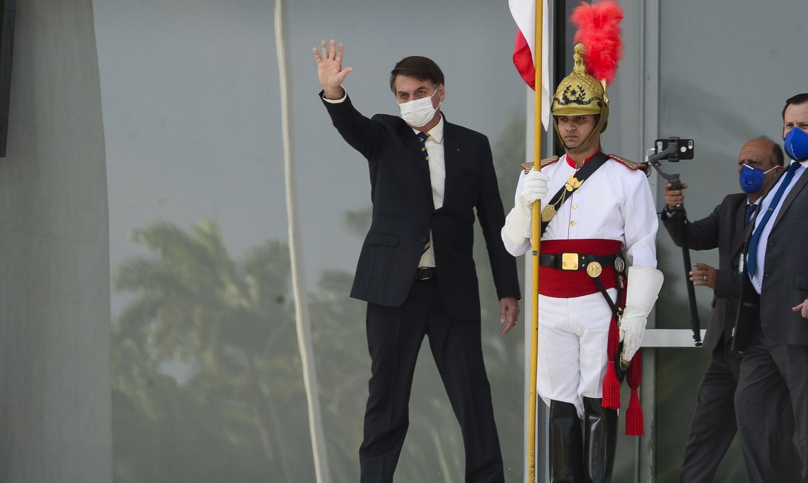 O presidente Jair Bolsonaro cumprimenta apoiadores da rampa do Palácio do Planalto