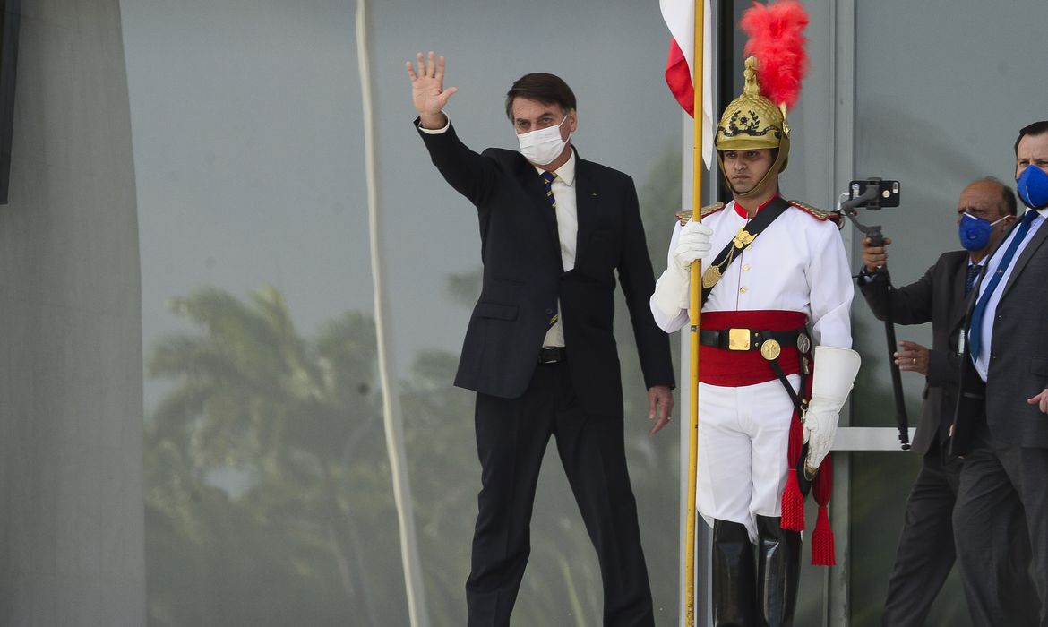 O presidente Jair Bolsonaro cumprimenta apoiadores  da rampa do Palácio do Planalto