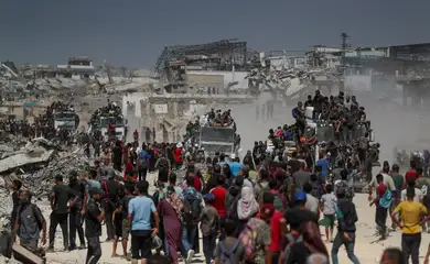 Palestinos carregam ajuda em Beit Lahia, norte de Gaza
 1/8/2025   REUTERS/Mahmoud Issa