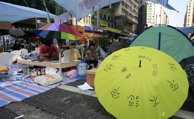 Protestantes pró-democracia descansam durante protesto por mais participação política que fechou ruas de Hong Kong, na China