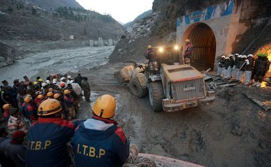 Members of Indo-Tibetan Border Police watch as a machine is used to clear a tunnel after a part of a glacier broke away, in Tapovan