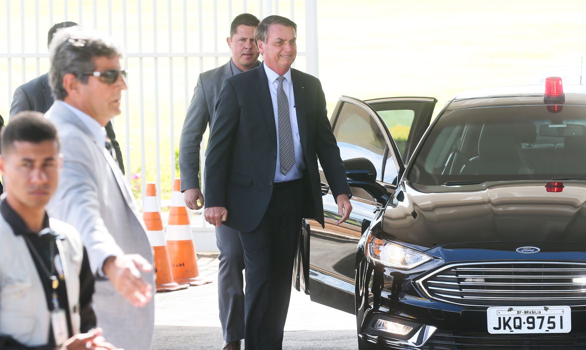 O Presidente Jair Bolsonaro cumprimenta populares ao sair do Palácio da Alvorada.