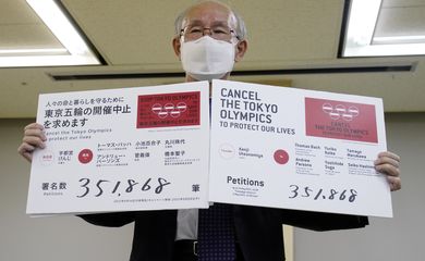 Advogado Kenji Utsunomiya exibe cartazes durante entrevista coletiva após envio de petição solicitando o cancelamento da Olimpíada de Tóquio - críticos - oposição a Toquio 2020