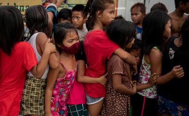 Crianças fazem fila para receber comida grátis distribuída por programa assistencial em favela em Manila, nas Filipinas, em meio à pandemia de Covid-19