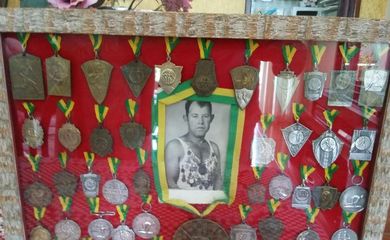 Ademir, filho de Adalberto, guarda as medalhas do pai em um quadro