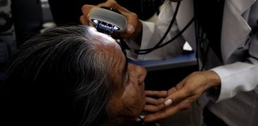 Médica examina pele de paciente idosa