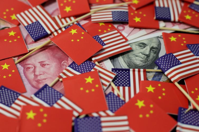 FILE PHOTO: A U.S. dollar banknote featuring American founding father Benjamin Franklin and a China's yuan banknote featuring late Chinese chairman Mao Zedong are seen among U.S. and Chinese flags in this illustration picture taken May 20, 2019.
