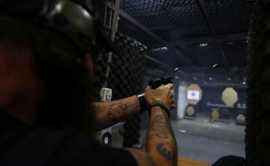 Joao Bercle, instructor of the Colt 45 shooting club, fires a gun, in Rio de Janeiro