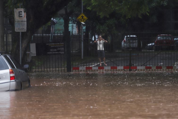 Um homem tira fotos de uma rua inundada após fortes chuvas no bairro Butanta, em São Paulo, Brasil, 10 de fevereiro de 2020. REUTERS / Rahel Patrasso