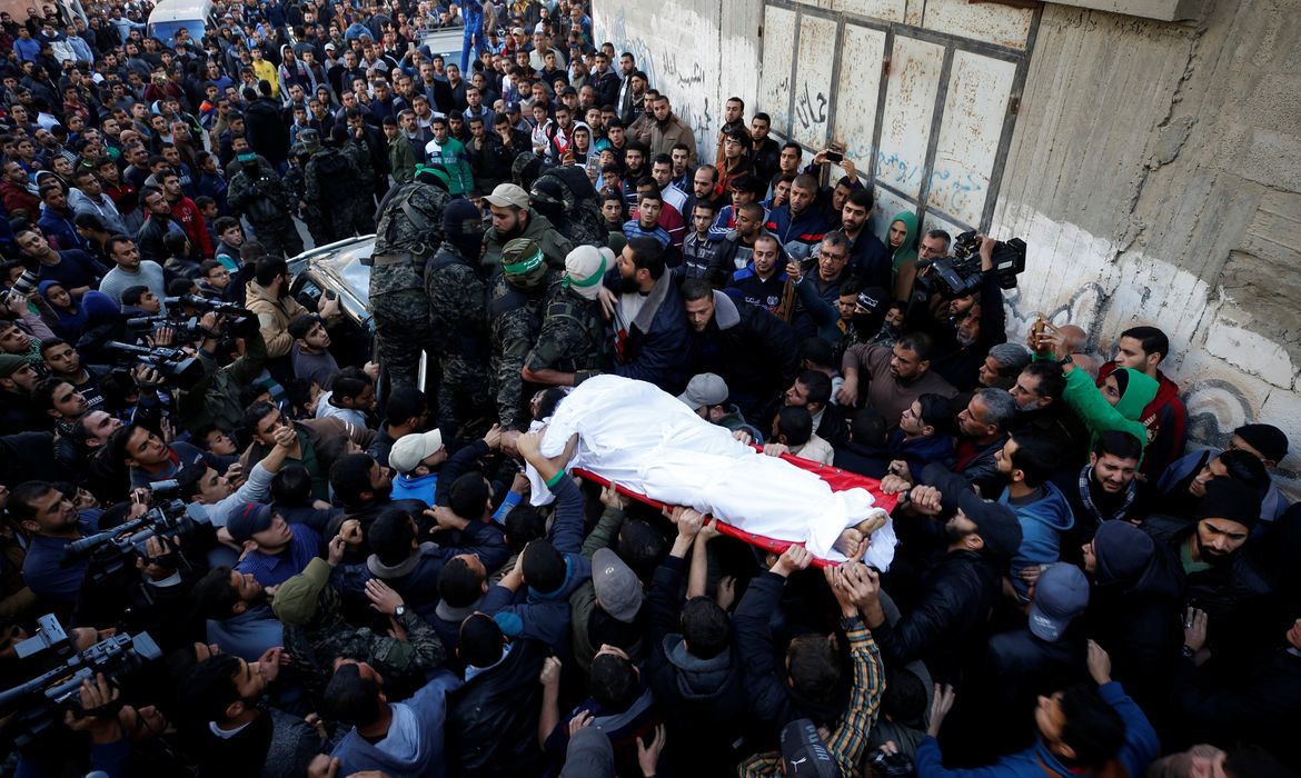 Militantes palestinos do Hamas carregam o corpo de um dos homens mortos em ataque aéreo israelense