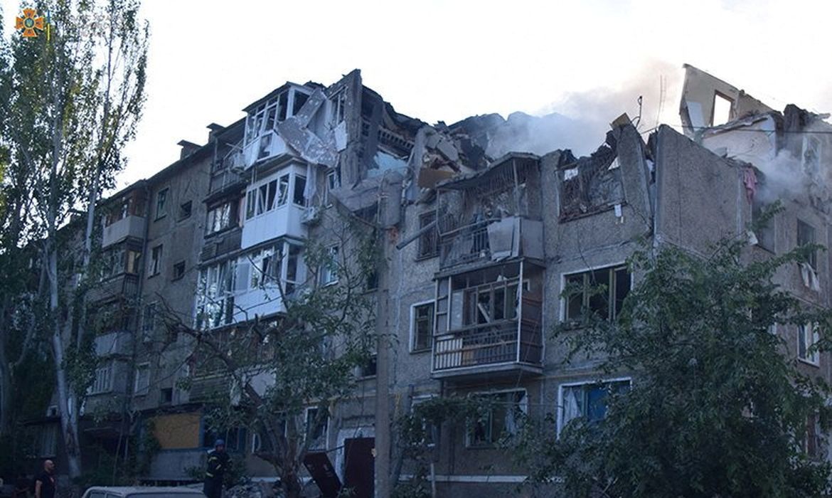 Membro de equipe de resgate perto de prédi residencial atingido por ataque militar russo em Mykolaiv, na Ucrânia