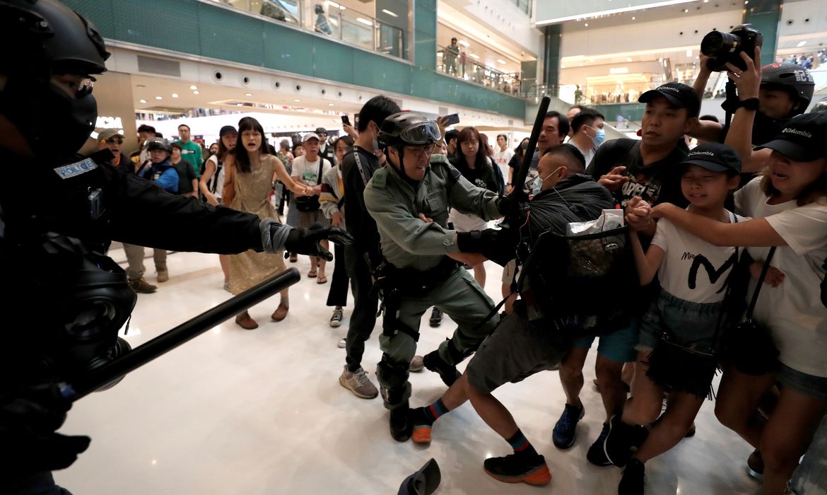 A man scuffles with a police officer as shoppers and anti-government protesters gather at New Town Plaza in Sha Tin, Hong Kong, China November 3, 2019. REUTERS/Shannon Stapleton