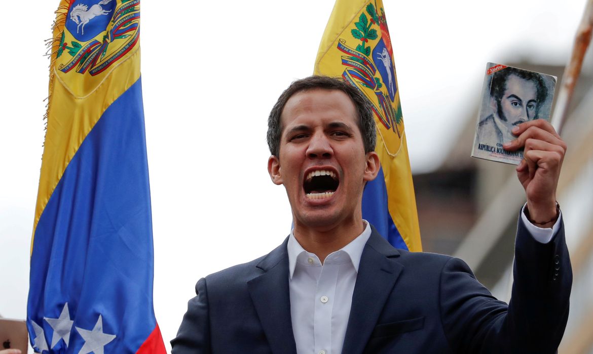 Juan Guaido, President of Venezuela's National Assembly, holds a copy of Venezuelan constitution during a rally against Venezuelan President Nicolas Maduro's government and to commemorate the 61st anniversary of the end of the dictatorship of