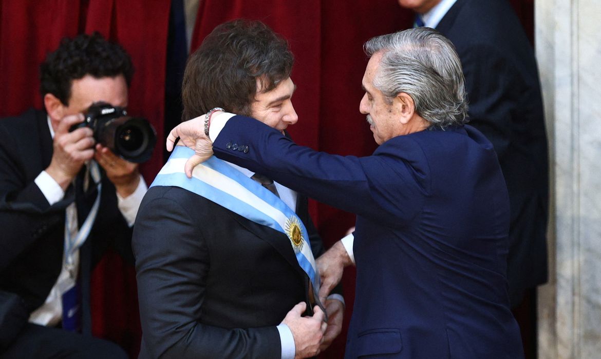 Outgoing Argentine President Alberto Fernandez passes the presidential sash to Javier Milei after he was sworn in as Argentina's next president, in Buenos Aires, Argentina December 10, 2023. REUTERS/Matias Baglietto