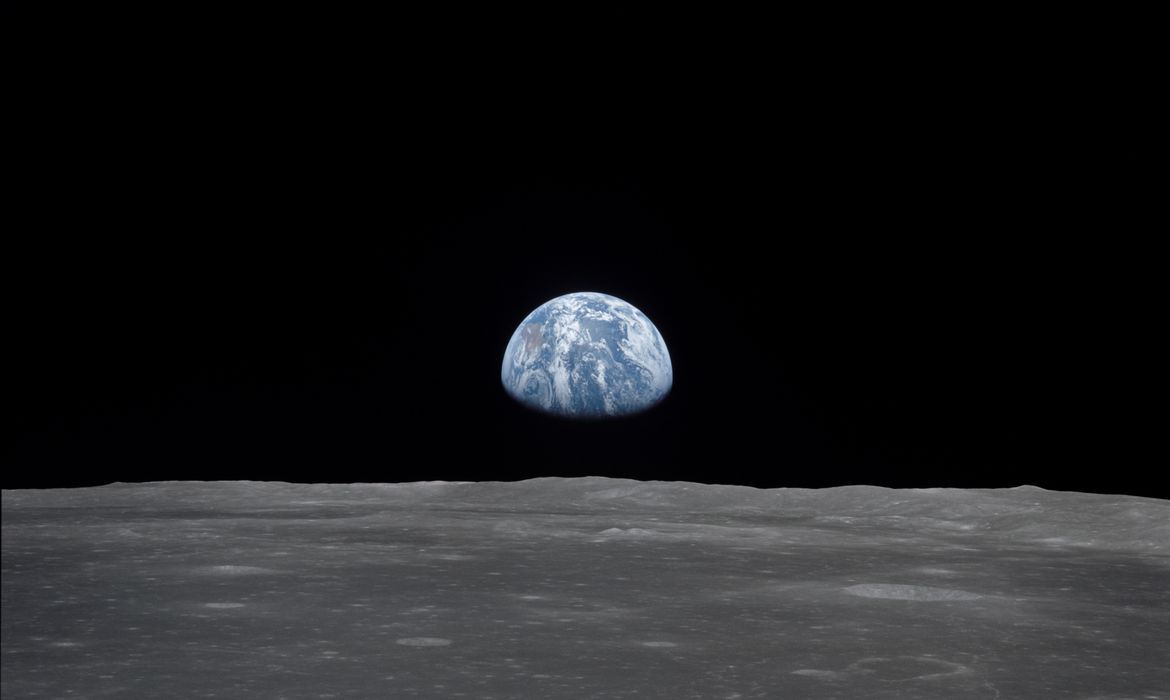 View of Moon limb with Earth on the horizon,Mare Smythii Region. Earth rise. This image was taken before separation of the LM and the Command Module during Apollo 11 Mission. Original film magazine was labeled V. Film Type: S0-368 Color taken