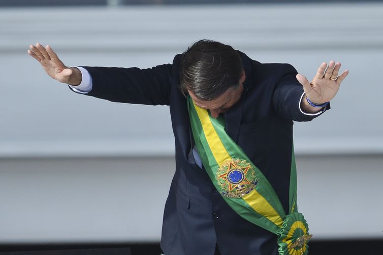 Presidente Jair Bolsonaro saúda o público depois de receber a faixa presidencial de Michel Temer, no Palácio do Planalto.