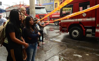 São Paulo - Bombeiros trabalham para conter incêndio em casa que abrigava imigrantes bolivianos no Brás, região central.