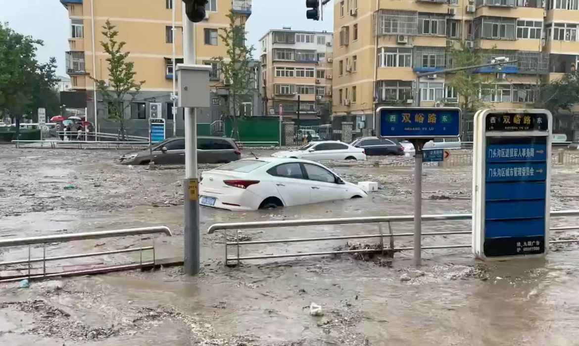 Water gushes on a flooded street following Typhoon Doksuri in Beijing