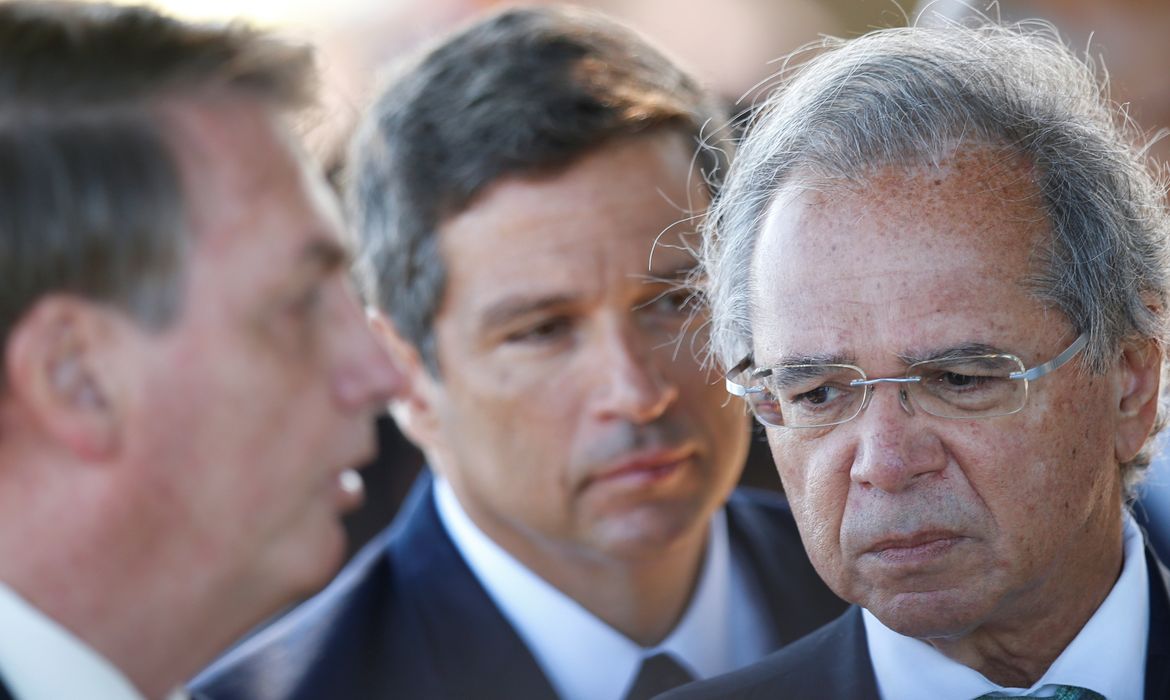 O ministro da Economia do Brasil, Paulo Guedes, fala perto do presidente do Brasil, Jair Bolsonaro, e do presidente do Banco Central do Brasil, Roberto Campos Neto, ao deixar o Palácio da Alvorada em Brasília.