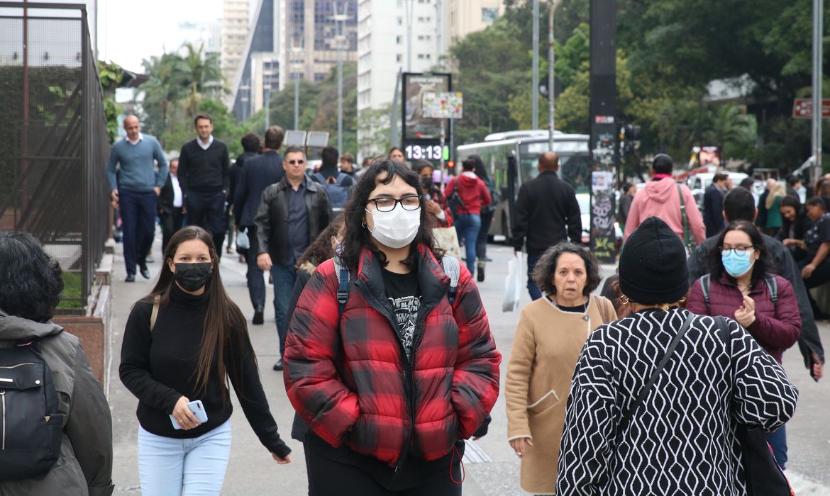 Pedestres na Avenida Paulista durante frente fria.