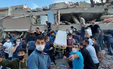 Moradores e oficiais procuram sobreviventes em um prédio desabado em Izmir