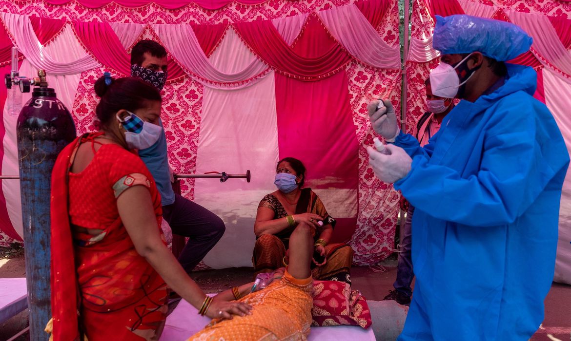 Mulher cercada por seus parentes recebe um suplemento de oxigênio no Templo Sikh Gurudwara em Ghaziabad