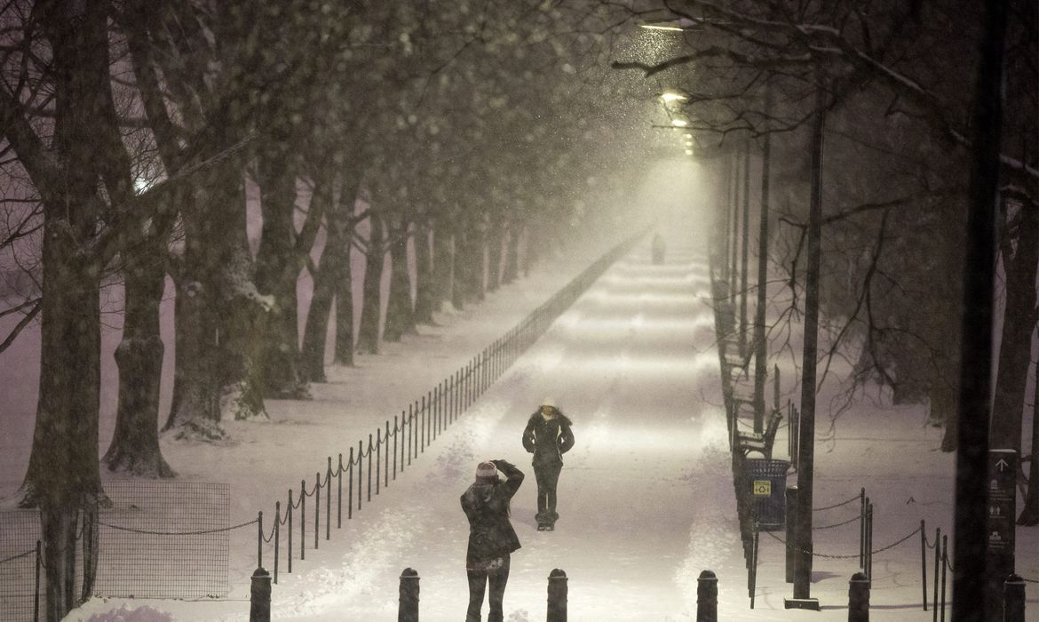 Pedestres param para tirar fotos em meio à tempestade de neve que atinge Washington e outras regiões dos Estados Unidos (Agência Lusa/Direitos Reservados)