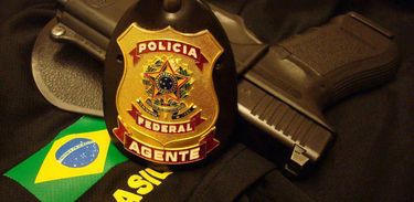 Distintivo da Polícia Federal do Brasil e pistola glock 9mm