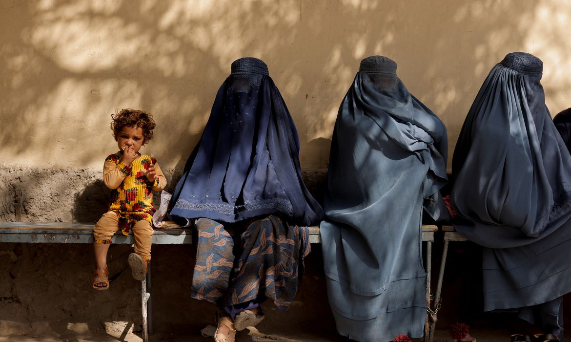 Menina afegã ao lado de três mulheres de burca em hospital de Cabul
