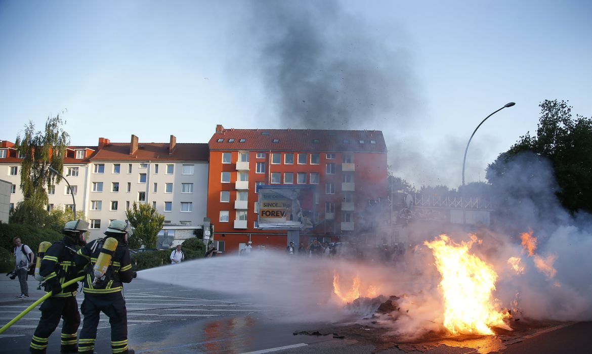 Bombeiros atuam no combate a incêndio em veículo provocado durante os protestos contra o G20 em Hamburgo
