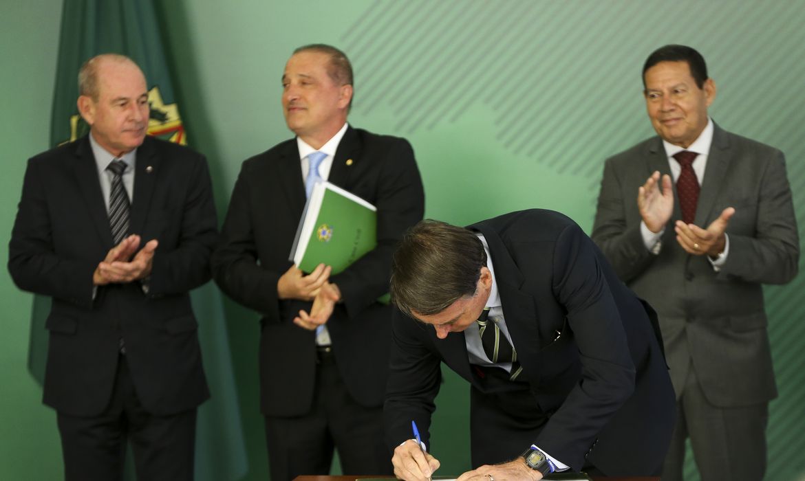 O presidente Jair Bolsonaro, o ministro da Defesa, Fernando Azevedo, e o ministro da Casa Civil, Onyx Lorenzoni, durante cerimônia de assinatura do decreto que flexibiliza a posse de armas no país. 