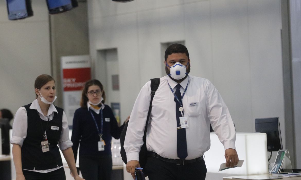 Passageiros e funcionários circulam vestindo máscaras contra o novo coronavírus (Covid-19) no Aeroporto Internacional Tom Jobim- Rio Galeão