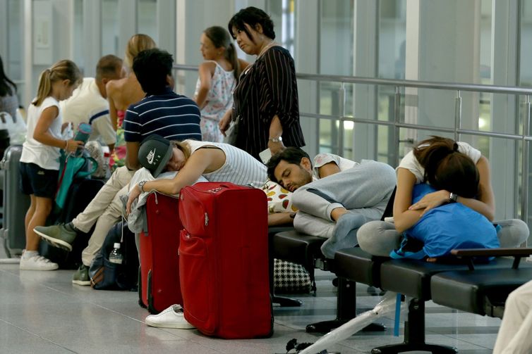Turistas dormem em uma estação de trem depois que várias linhas foram canceladas por causa do tufão Jebi