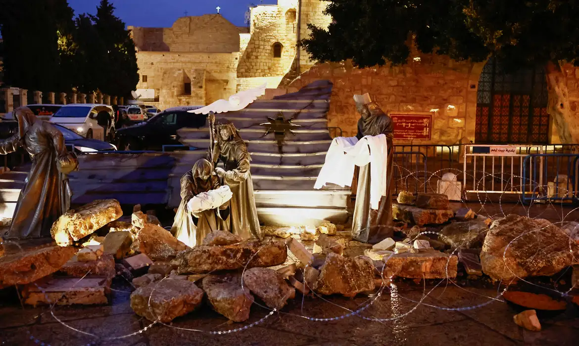 Figuras religiosas em meio a escombros e cercadas por arame farpado, como forma de apoio a Gaza, do lado de fora da Igreja da Natividade, na Praça da Manjedoura, em Belém, na Cisjordânia ocupada por Israel.
23/12/2023
REUTERS/Clodagh Kilcoyne