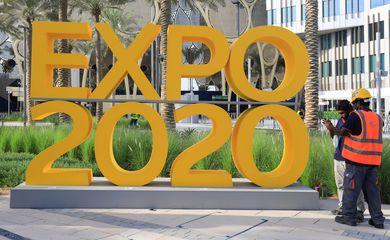 Workers are pictured next to the Expo 2020 logo ahead of the opening ceremony in Dubai
